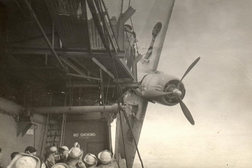 USS Sable (IX 81) showing a TBF hanging over the side after crashing during carrier qualifications on Lake Michigan.