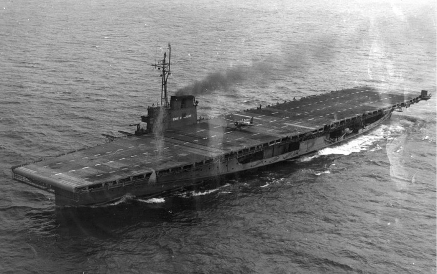 Overhead view of the training aircraft carrier 'Sable' (IX 81) underway on Lake Michigan with an FM Wildcat making a deck launch from the flattop 1945