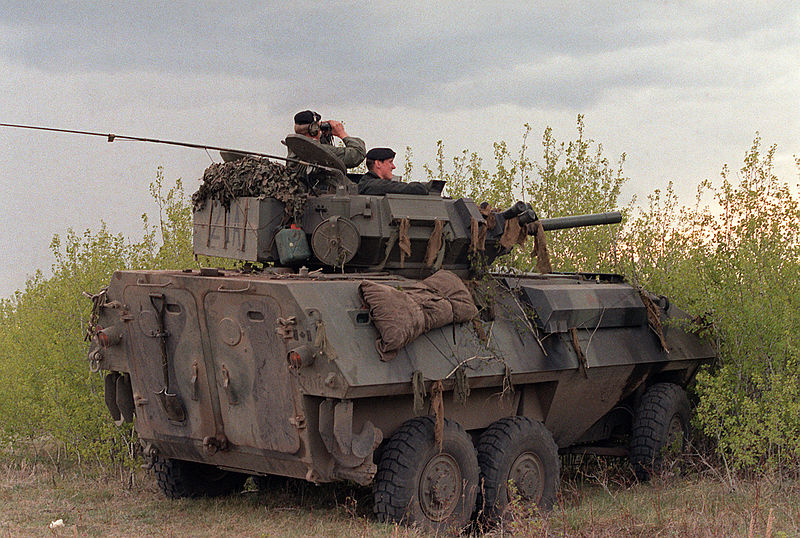 A right rear view of a Canadian army Cougar wheeled fire support vehicle that is being used as an observation post by soldiers standing watch during the combined U.S./Canadian NATO Exercise Rendezvous '83. Location: Camp Wainright, AB